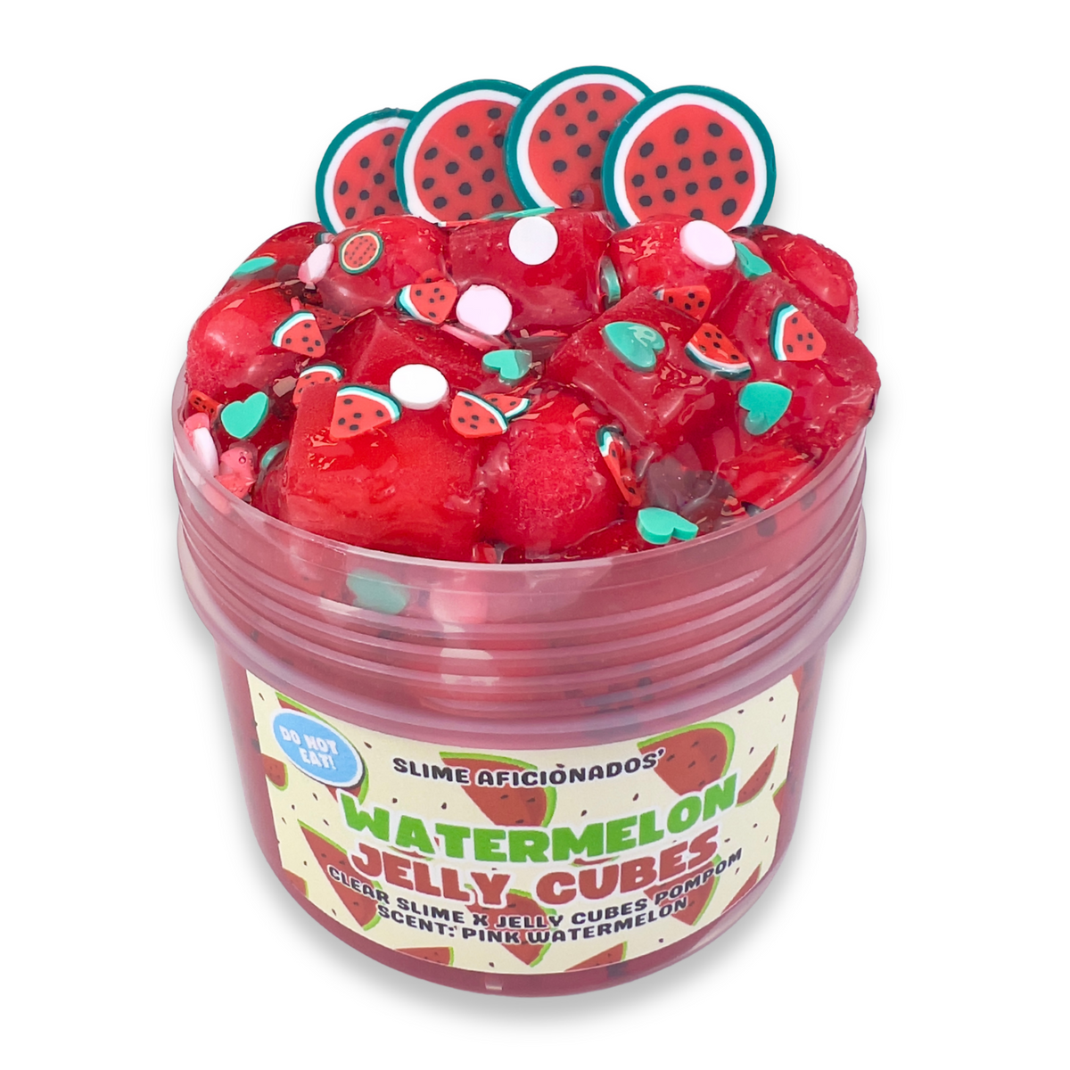 A clear plastic jar filled with red clear slime, red jelly cubes and topped with watermelon-themed decorations, including four watermelon slice charms and small green and white accents. The label reads 'Slime Aficionados' and 'Watermelon Jelly Cubes'.