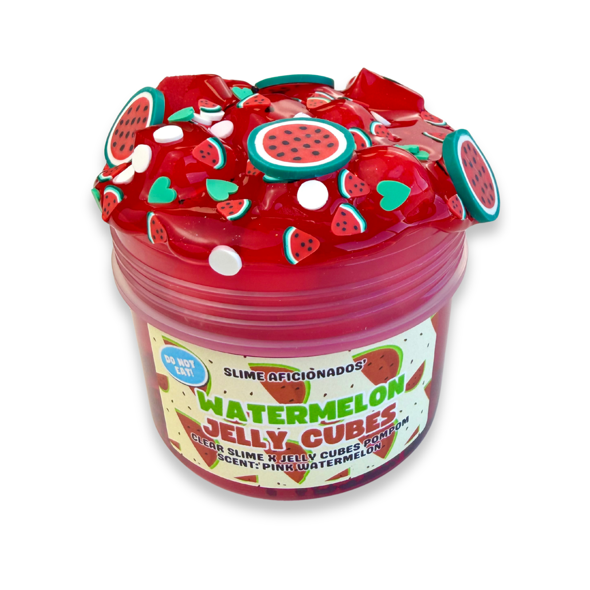 A jar of red slime topped with watermelon-themed decorations, including watermelon-shaped charms and heart and slice embellishments. The label reads 'Watermelon Jelly Cubes' and 'Slime Aficionados'.