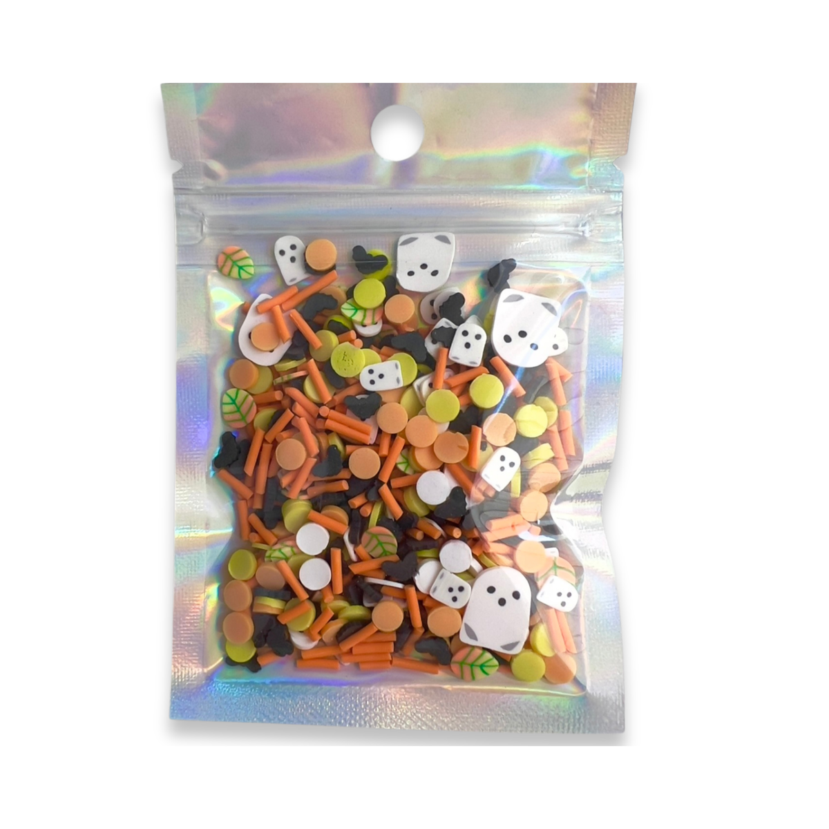 A clear holographic zip pouch containing a mix of Halloween-themed craft embellishments, including orange sticks, white ghosts, black and white cat faces, and small green and yellow pieces, shown on a white background.