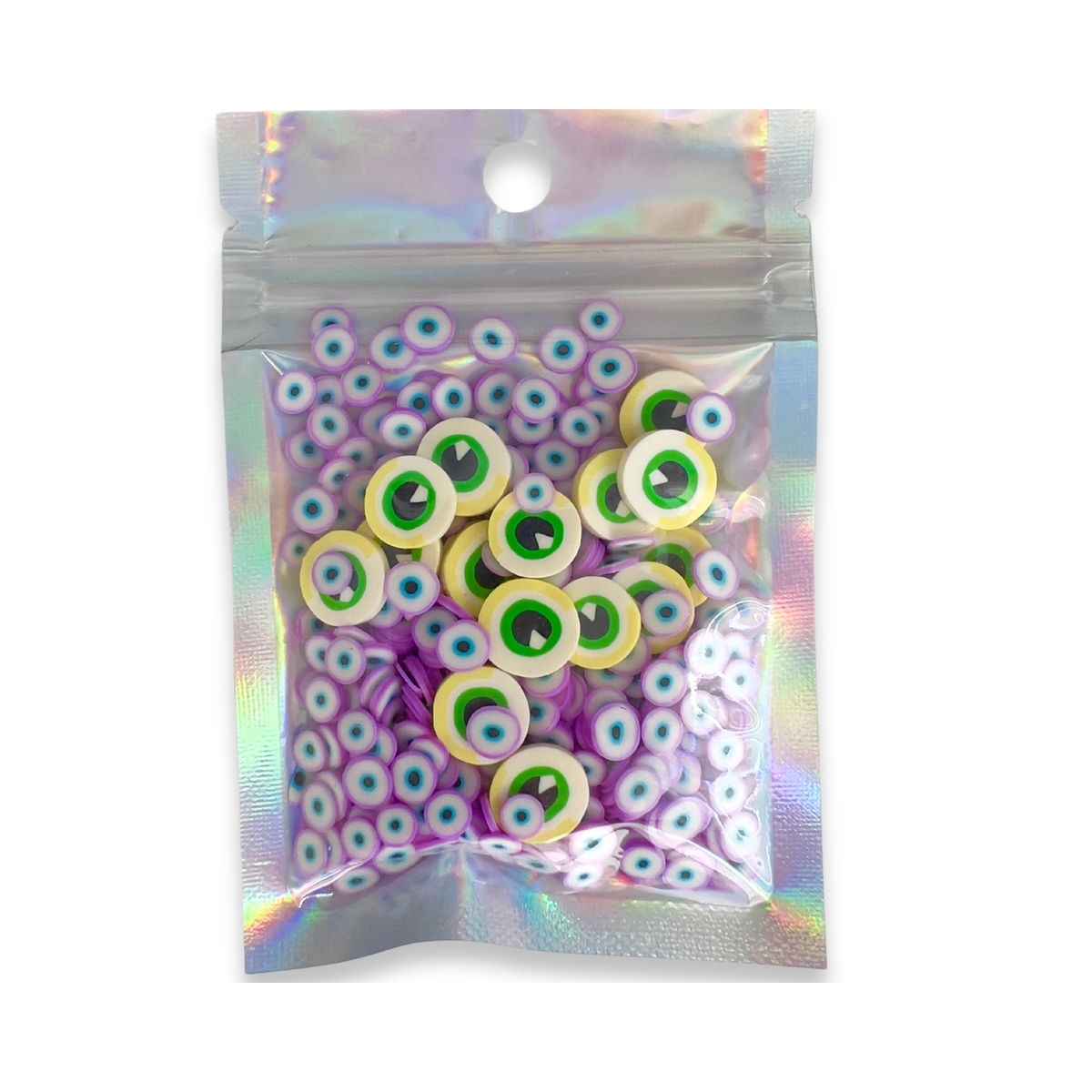 A clear holographic zip-top pouch containing many small circular eye-shaped embellishments or beads, shown on a plain white background.